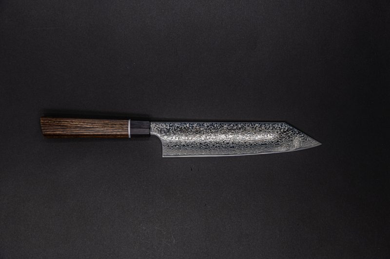 Ein Küchenmesser im japanischen Stil mit gemusterter Klinge und dunklem Holzgriff steht auf einem dunklen, soliden Hintergrund.