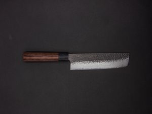 Das Gen - Nakiri 150mm, ein Küchenmesser im japanischen Stil mit dunklem Holzgriff und gehämmerter, strukturierter Klinge, wird auf einem schlichten, dunklen Hintergrund präsentiert.