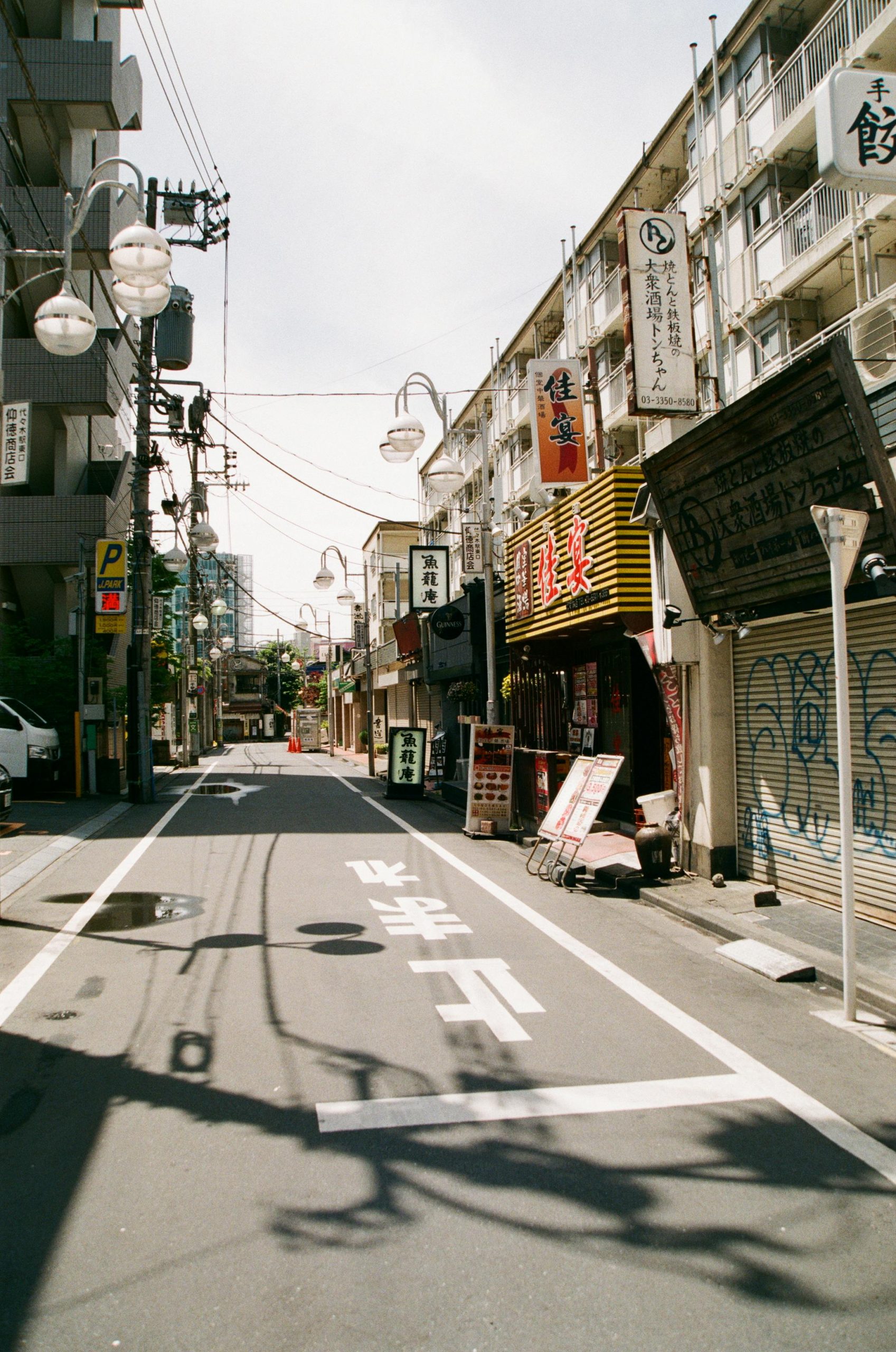 Eine ruhige Straße in Japan, gesäumt von kleinen Geschäften und Restaurants