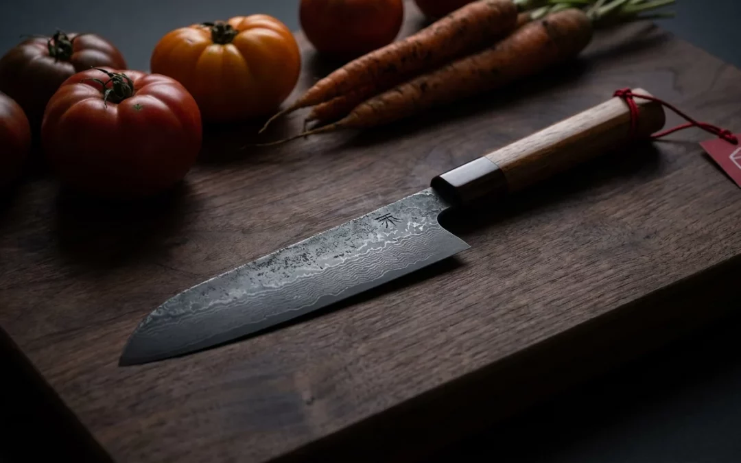 Ein neues erstes japanisches Messer liegt bereit auf einem Holzbrett mit frischem Gemüse.